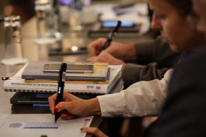 Participants in the 2018 Human Dimension Implementation Meeting test digital pens used by ODIHR election observers at an interactive side event. Warsaw, 11 September 2018. (OSCE/Maria Kuchma)